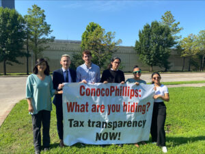 picture of Oxfam and Public Citizen holding large sign that says "ConocoPhillips: What are you hiding? Tax transparency NOW!"